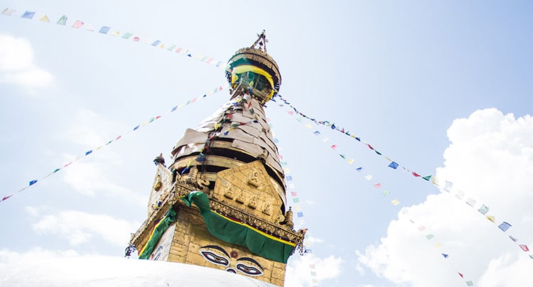 Photo of a top of a stupa in a beautiful cloudy sky - a symbol of the Buddhist 8 fold path