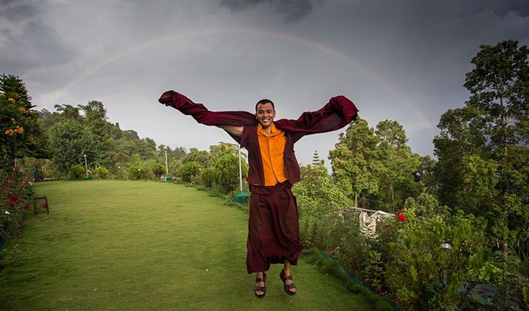 A Buddhist monk with a beautiful full rainbow - symbolizing equanimity