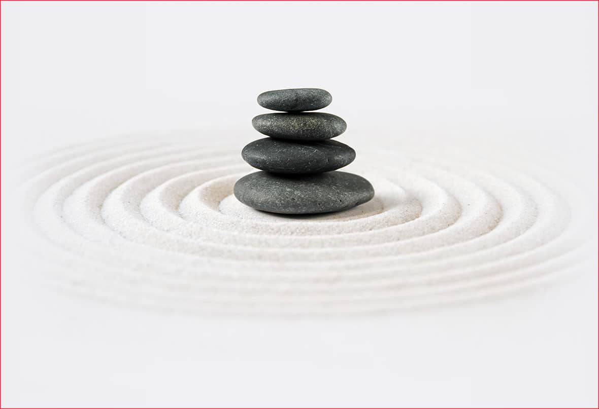 An image of 4 smooth rocks creating waves in sand, the 4 immeasurables